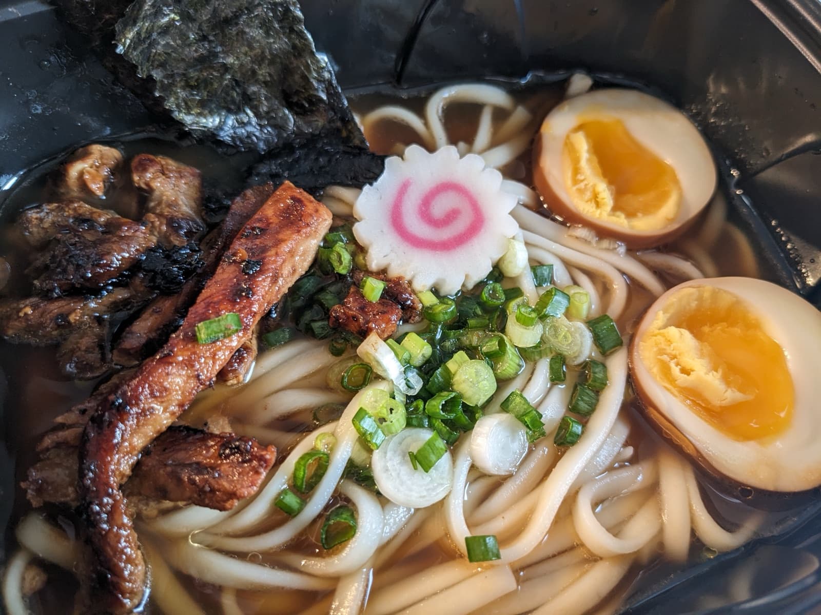 Bol de ramen du O’ptigrain : nouilles udon, bouillon, porc grillé, œuf mollet, naruto et cébette.