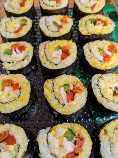 Plateau de makis garnis de crevettes, poivron et avocat, roulés dans une feuille de nori.